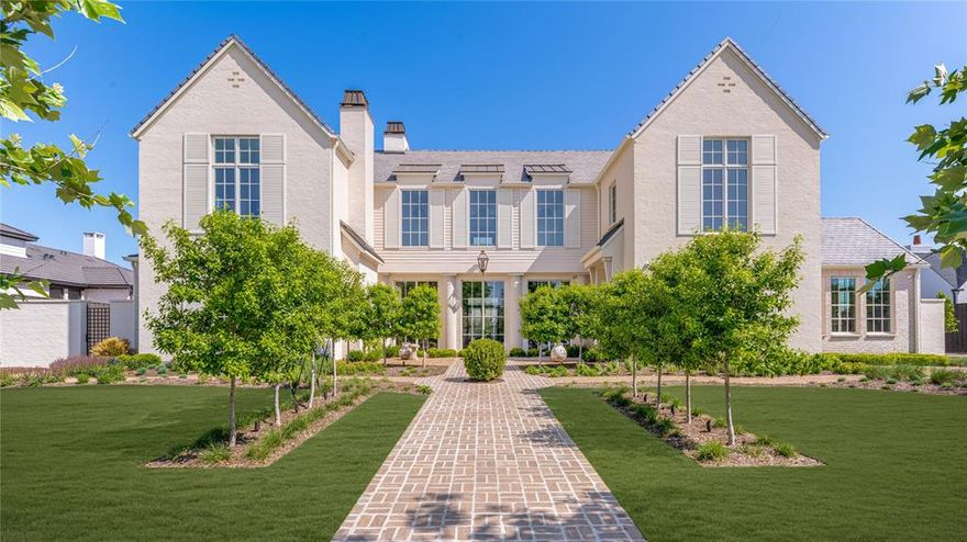 Discover an exceptional new build in Dallas’ prestigious Preston Hollow. This 7,855 sqft estate offers 5 bedrooms, 6 full and 2 half baths on a lush half-acre lot. The painted brick and stucco exterior pairs with a Davinci slate roof, while Bloom&Grow’s landscaping frames a 40-foot pool and spa. An oversized four-car garage with dual access adds convenience. Inside, the grand double-height foyer with custom iron railing and limestone floors sets the tone. The living room, study, and primary suite each feature wood-burning fireplaces, complemented by hand-troweled ventian plaster and custom cabinetry throughout the first floor. The chef’s kitchen includes Thermador appliances, Waterworks fixtures, quartzite counters, a walk-in pantry, and a butler’s prep kitchen. The luxurious primary suite offers a coffee bar, spa-like limestone and travertine bath, and an oversized dressing room with private laundry. Speakers and smart home integration systems in key rooms make this home as functional and secure as it is beautiful. Built by Pierce Jordan Development and designed by Shane&Pierce, experience refined living at 5609 Ursula Lane — where timeless elegance meets modern luxury.
