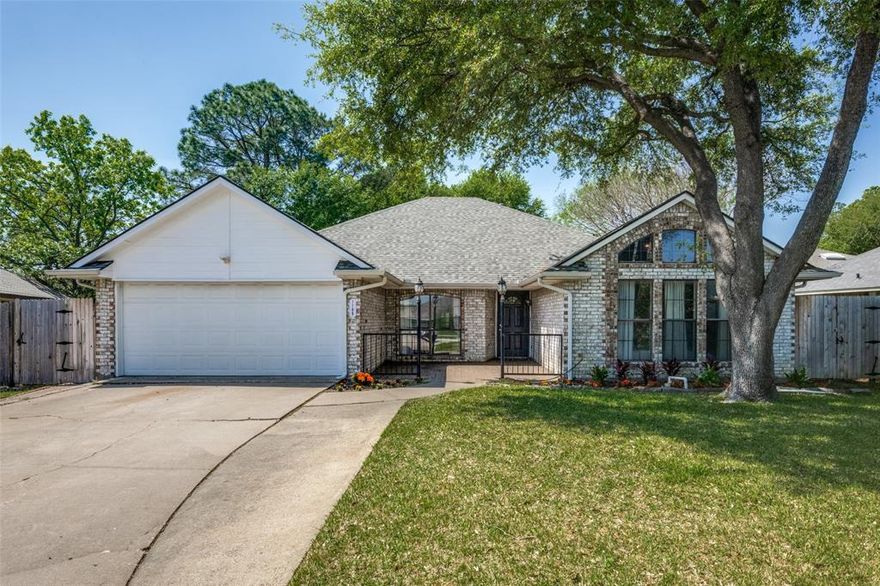 Tucked into the established Prairie Creek community in Flower Mound and zoned to sought-after Lewisville ISD, this inviting home blends timeless character with everyday comfort—without the restrictions of an HOA!  A welcoming gated courtyard sets the tone, offering a private and charming entry into a home filled with architectural details you don’t often find—soaring ceilings, elegant crown molding, and beautiful curved windows that flood the space with natural light. Multiple living areas provide flexibility for both relaxing and entertaining, anchored by a cozy gas fireplace and custom built-ins that add warmth and functionality.  The kitchen features granite countertops, a custom backsplash, breakfast bar and abundant cabinetry, all flowing seamlessly into the main living spaces—perfect for gathering. Thoughtfully designed with solid surface flooring throughout, including hardwoods, LVT, parquet, and concrete, this home offers both style and durability.  The spacious primary suite is a true retreat with its own private access and a spa-like bath, while three additional bedrooms provide room for family, guests, or a home office.  Step outside to your own backyard escape—an elegant, shaded sport pool surrounded by mature trees, creating a peaceful setting for summer days and evening unwinding.  With a refrigerator included and a cul-de-sac location in one of Flower Mound’s most beloved neighborhoods, this home is the perfect blend of charm, space, and lifestyle.