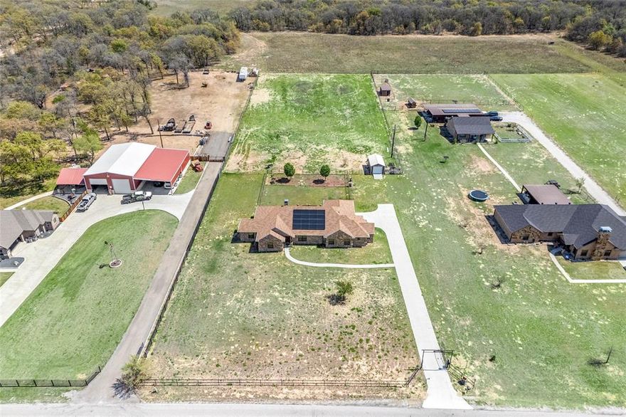 How does 2 full acres of beautiful serene peaceful country style living with a stunning fully bricked single story home that offers 4 bedrooms with 2.5 baths sound?  And NO HOA!
This is Country living at its finest! This gorgeous 2500 sq ft. home offers so many luxurious amenities including a solar panel roof to keep the Hot Texas summer electric bills at a bare minimum.  You will be dazzled by the beautiful Texas sized Master bath with huge walk in shower with two separate shower heads. A glorious walk in separate bath tub and a large vanity.  This home offers very attractive stained concrete flooring throughout, water softener and a reverse osmosis filtration system in the kitchen.  Enjoy the beautiful sunsets from the oversized back covered patio with two overhead fans to keep you cool and refreshed and a TV as well. Entrance to the property contains an added security measure with a cross gate covering the very lengthy driveway. The magnificent kitchen with granite counter tops throughout offers a double oven for convenient large gathering holiday entertaining.  The extensive open living room offers a gorgeous colossal sized bricked wood fireplace as the center piece for the entire home. Not to be outdone,  this home is located on two beautiful acres of country style living with plenty of space for all types of family activities with No HOA! Also, a large shed with electricity sits near the rear of the home.  This is a home to just kick back and enjoy!