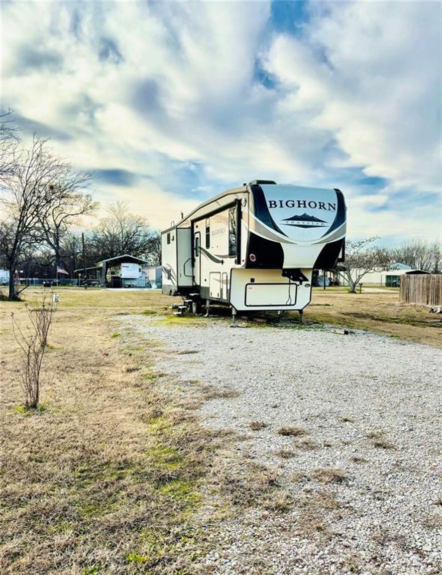 Lake Fork living starts here in the gated community of Holiday Villages of Fork! This spacious 40x80 lot offers a full RV setup, including a water spigot, extra-long driveway, installed sewer pump, electrical panel, and dedicated RV plug—ready for immediate use. Also negotiable with the sale is a 2017 Heartland Bighorn fifth wheel, a top-of-the-line RV that comes fully furnished and loaded with upgrades.

Inside the Bighorn, you’ll find dual air conditioning systems, central vacuum, a kitchen island, French-door refrigerator, electric fireplace, built-in radio system, ceiling fan, two reclining massage chairs, and a fold-out couch—perfect for relaxing or entertaining. The private bedroom features a king-size bed, washer dryer hookups, and generous closet space. The open layout offers a comfortable flow for dining, lounging, and hosting guests.

Holiday Villages of Fork is a secure, gated community offering resort-style amenities and an active social calendar. The mandatory HOA is $52 per month. Community well water filtration and sewer services are $65 each per month, plus usage.

Bring your golf cart, ATV, boat, and fishing gear and enjoy everything this outdoor-friendly community has to offer, including two fishing piers, boat ramps with access to Lake Fork, a clubhouse, saltwater pool, playgrounds, basketball court, and covered picnic areas. Residents enjoy monthly potlucks, bingo, karaoke, paint classes, weekly social clubs, and festive holiday events.

Whether you’re seeking a weekend getaway or full-time Lake Fork living, this property delivers comfort, convenience, and community.