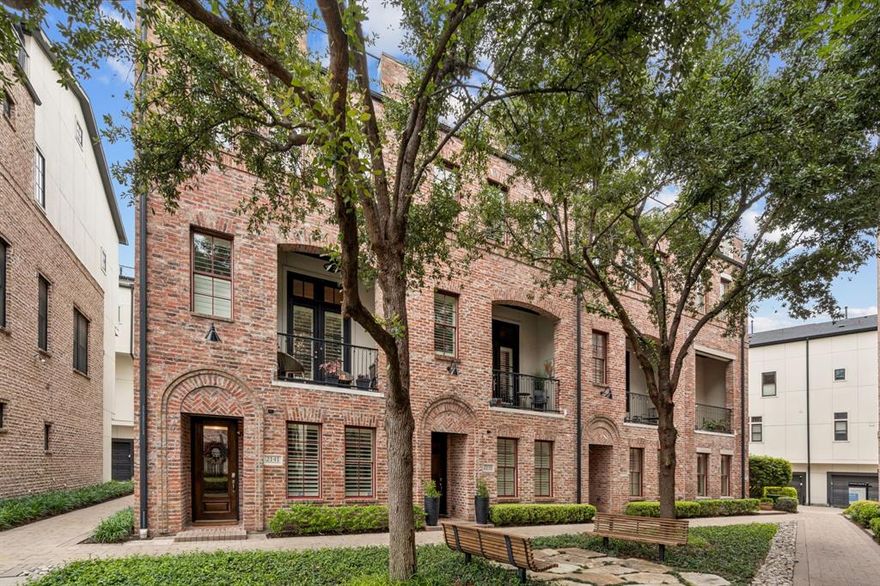 Experience elevated urban living in this stunning 4 story luxury townhome directly across from the Dallas Farmers Market, featuring designer upgrades & a fully enhanced rooftop terrace with skyline views. Ideally situated as an interior end unit, this home benefits from additional windows & abundant natural light, along with close proximity to the community pool—offering both privacy & convenience within the neighborhood.
Thoughtfully designed w 3 bedrooms & a highly functional floorplan, the home blends flexibility, comfort & modern sophistication. A first-floor bedroom w ensuite bath & double doors provides the perfect space for guests, a private office or fitness room. The main living level is built for entertaining, showcasing an open-concept layout with continuous wood flooring throughout the home, plantation shutters, designer lighting, and seamless indoor-outdoor flow to a private balcony. The chef’s kitchen features premium quartzite countertops, a large island, gas cooktop, white cabinetry and abundant storage, delivering both elevated design and durability. Upstairs, the spacious primary suite serves as a true retreat, complete with a stone fireplace and spa-inspired bath featuring a soaking tub, separate shower, dual vanities & an oversized walk-in closet. An additional bedroom & conveniently located laundry complete the level. The defining feature of the home is the rooftop terrace, designed for year-round use with turf flooring, a custom awning, integrated misting system & gas connection for a fireplace or outdoor kitchen—all set against sweeping Downtown Dallas skyline views. This space functions as a true extension of the home’s living and entertaining area. Located in a beautifully maintained community with pool & walkable access to the Farmers Market, dining, coffee & entertainment, this home offers a rare combination of enhanced natural light, consistent high-end finishes, functional outdoor living & superior positioning within the community.