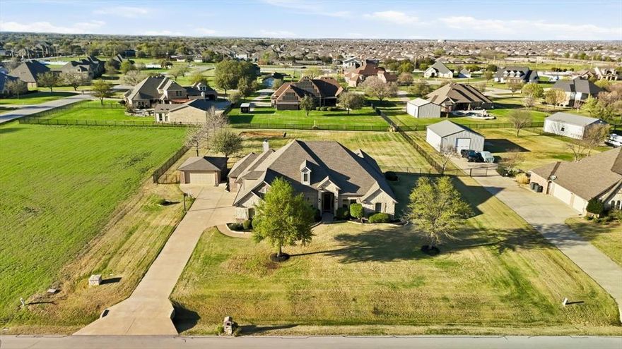 THE WHOLE PACKAGE! Experience luxury living at this executive custom home on a spacious 1-acre lot in sought-after Willow Springs Ranch! This property offers the perfect blend of modern luxury & peaceful country living, complete with a sparkling pool, expansive backyard & additional detached brick garage ideal for a car collection, boat or workshop! This turn-key home features extensive high-end designer updates, including a remodeled kitchen & bathrooms, along with gorgeous hardwood flooring throughout that adds warmth & timeless elegance. Designed with Texas hospitality in mind, the interior offers plenty of space for guests to gather, including 2 living & 2 dining areas. The stunning island kitchen is the heart of the home, showcasing new quartz countertops, abundant oak cabinetry & seamless flow into the sunny breakfast nook, spacious living room & formal dining area. A private office off the entry provides an ideal work-from-home space. The split-bedroom layout ensures privacy, highlighted by a luxurious primary suite featuring a soaking tub, oversized walk-in shower & dual vanities. Generously sized secondary bedrooms with ample closets offer flexibility & could easily accommodate multi-generational living. Added bonus of a walk-up attic, with easy access & offering excellent storage or potential future living space. Step outside to your backyard oasis & enjoy breathtaking sunsets from the expansive patio. Spend summers in the play pool with water feature & tanning ledge or unwind on the porch grilling with friends! The oversized attached garage accommodates larger vehicles, while the detached garage provides additional room for hobbies & storage with total covered parking for 5 vehicles. Property features established lawn, professional landscaping with stone borders, sprinkler system & private well to save $ with NO water bills. No HOA. Located in acclaimed Northwest ISD. All the hard work is done, so come live your best life in this exceptional property!