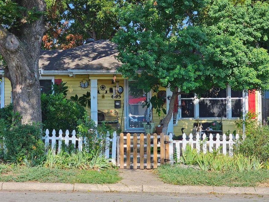 You must see this adorable yellow 1950's Bungalow with its welcoming covered front porch. Inside is a spacious living room with wood floors. You will find an eat-in Kitchen with washer and dryer hook ups behind separate shuttered doors. The very large  bedrooms are divided by a sizable hallway that that could accommodate a small office desk. The bathroom was remodeled several years ago and has a tiled shower with glass doors and a vessel sink. Flooring is laminate with wood in the living area and front bedroom. Each room has ceiling fans. There is a carport on the left side of the home and behind it farther back in the yard is a garage. There are several buildings and shelters in the back yard as well as a small covered back porch off the back door of the home.