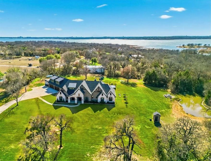 Stunning custom estate in Flower Mound offering 3.093 acres of private, unrestricted land with no HOA, just steps from Grapevine Lake, Merrill Park, and Twin Coves Marina. Built in 2021, this thoughtfully designed custom home combines modern construction with functional luxury. The main level features five bedrooms, each with access to a full bath, providing exceptional flexibility for families, guests, or multigenerational living. A well appointed chef’s kitchen anchors the heart of the home, designed for both everyday living and entertaining with generous workspace and seamless flow into the main living areas. Upstairs, an approximately 1,000 square foot bonus room offers versatile space for a game room, media room, or additional living area, complemented by a fully decked attic for abundant storage. Additional interior highlights include an oversized utility room and thoughtful details throughout that reflect the quality of a true custom build. The outdoor setting is equally impressive, featuring a resort-style pool and spa, expansive outdoor kitchen and living area, private pond, and dedicated RV or Boat parking. A 950 foot deep well supports irrigation and outdoor needs, while the four car garage provides ample space for vehicles, storage, or hobbies. Ideally located near shopping, dining, and exemplary schools, with DFW International Airport less than 10 miles away, this exceptional Flower Mound property offers privacy, acreage, modern construction, and access to North Texas lake living