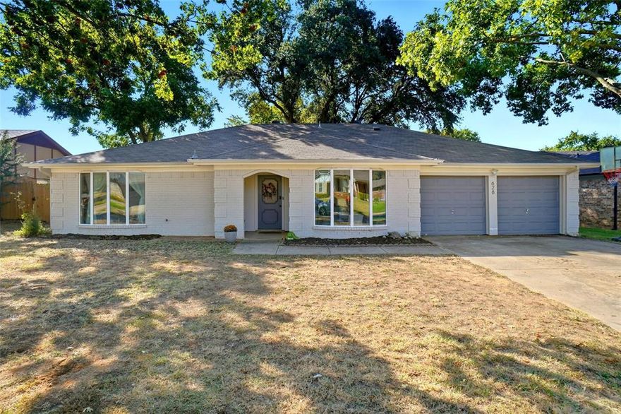 Sometimes a home just feels right the moment you walk in—and this Bedford charmer is exactly that kind of place. Tucked quietly inside the established Camelot Estates neighborhood, this single-story home offers comfort, warmth, and everyday living made easy. Step through the front door and into a light-filled step down living room where a painted brick fireplace becomes the centerpiece—perfect for slow mornings, movie nights, and cozy winter gatherings. The nearby dining spaces give you freedom to create what best fits your lifestyle: formal dining, a home office, a homework zone, or a flexible second living area. Galley kitchen has granite countertops, double oven, built-in cabinetry, and a breakfast nook overlooking the backyard—ideal for casual meals or weekend baking sessions. Thoughtful features like split bedrooms, walk-in closets, and seperate vanities in the primary suite bring comfort and privacy to everyday routines. Outside, enjoy the fenced backyard, shaded by mature trees and offering plenty of room to garden, play, or unwind. A charming play fort gives kids their own world to explore, and the open grassy area provides endless possibilities for outdoor living or future enhancements. Located minutes from Bedford parks, nearby shops, dining, and award-winning Hurst-Euless-Bedford ISD schools, this home offers convenience to DFW Airport, major highways, and nearby communities like Colleyville and Grapevine. Whether you're starting a new chapter or looking for a place to plant deeper roots, this Bedford home offers space, charm, and practicality in a setting that feels truly welcoming.