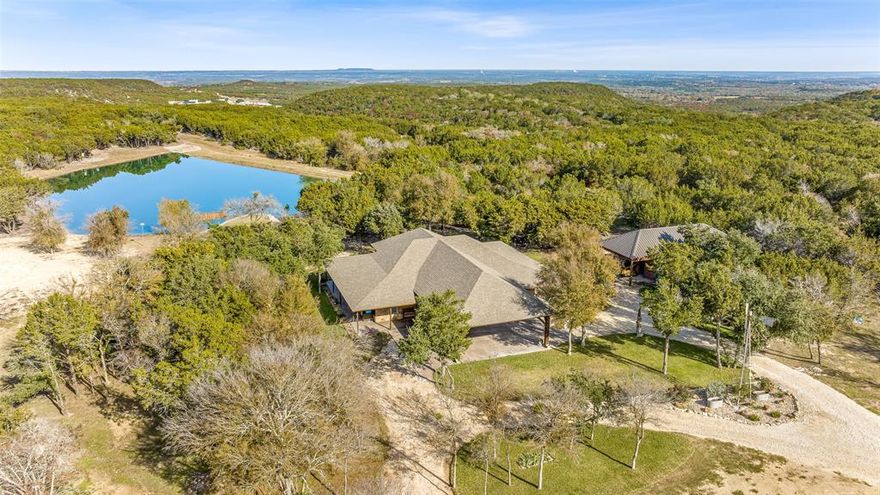Beautiful custom home with private lake on 20 secluded acres that could also be repurposed as a short-term vacation rental or a special events venue. Property has dense tree cover that provides excellent wildlife habitat and is bordered on 2 sides by large, undeveloped ranches. The 1-acre lake has 20 ft depth and is stocked with multiple species of bait fish, plus crappie, black bass, and channel cat. All 4 sides of the property are cleared at the boundaries, and perimeter fencing exists on 3 sides. The 2,166 sqft home has an impressive 30x35 covered parking area at the entrance, as well as covered porches with lighting on the remaining 3 sides, all of which feature stamped, stained concrete. These porches create a dramatic outdoor living space with views of the beautifully landscaped yard with St. Augustine grass and walkway to the lake.

The home's entryway leads into a spacious living area with vaulted wood ceilings with exposed beams and a stacked-stone WB fireplace with insert. The open concept design also features a roomy kitchen and dining space with large windows overlooking the backyard and lake. The kitchen has granite countertops, propane oven-stove, and stainless appliances. It also has a large island with electricity, a granite prep space, and a custom cedar countertop on the dining space. The primary bedroom and bath have exposed wooden beams, wood floors, his-her walk-in closets, separate vanities with cedar countertops, and a large, tile shower. The home also incorporates energy efficient features such as Low-E windows and open cell foam insulation. Outbuildings include storage space with a roll-up door and room for parking, and it also houses the well water storage tank.

The location is convenient to both Glen Rose and Stephenville, as well as the Metroplex and Waco. Road frontage includes 800+ ft of paved County Road 2012 frontage. Glen Rose ISD.