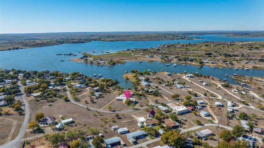 Discover beautiful water views from this classic 3-bedroom lake home, perfectly positioned on a quiet cove in the close-knit Lake Coleman community. Immaculately maintained and thoughtfully designed, this waterfront retreat offers comfort, convenience, and plenty of space for lake living. The huge living room overlooks the water, providing stunning views and the perfect place to gather with family and friends. The kitchen offers an abundance of space for entertaining and hosting, featuring a one-of-a-kind low breakfast bar, abundant cabinetry, and generous counter space. A large bay window fills the adjoining dining area with natural light and can double as extra seating. Bedrooms and bathrooms are spacious throughout, and the laundry room provides room for an additional fridge or freezer, ideal for extended stays or guests. Step outside to enjoy your own lakefront setup complete with a private boat ramp and a partially built boat dock, giving you a head start on creating your ideal waterfront escape. An additional lot expands the property, offering extra room to entertain, build, or further customize your lake oasis. You’ll also find extensive storage and parking options with an RV carport and another carport that connects the shop to the home. Multiple outbuildings provide endless possibilities for storing lake toys, creating workshop space, or converting into additional guest quarters. Fully furnished and move-in ready, this property is set up for immediate enjoyment. Located within easy reach of Abilene, Brownwood, and San Angelo, this well-kept waterfront gem blends peaceful lake living with exceptional functionality. Located within easy reach of Abilene, Brownwood, and San Angelo, this well-kept waterfront gem blends peaceful lake living with exceptional functionality.