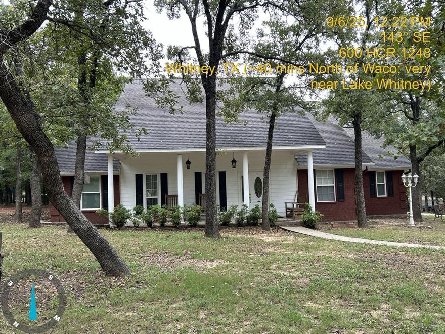 Discover serene, park-like living in this beautifully maintained 3-bedroom 2-bath home featuring a 2-car garage and sweeping views framed by mature post oaks, cedar elm, and hickory trees scattered throughout the grounds. The gated entrance, equipped with solar and electric power, leads to a spacious circular drive offering convenience and curb appeal. New fencing encloses the entire perimeter. Inside, the thoughtfully designed kitchen showcases granite countertops, pull-out drawers, under-cabinet lighting, and abundant storage- perfect for everyday use and entertaining. The split floor plan provides privacy with a generous primary suite featuring a large master bath and his and hers closets. The attic includes a fully insulated, electrically equipped bonus room, providing the perfect climate-controlled storage space. Additional highlights inside include a formal dining room, breakfast nook, large home office and large utility room both equipped with pocket doors, tray ceilings, a plethora of storage, and a striking brick fireplace with a propane starter for wood-burning ease. The backyard features a wooden deck and back porch TV access, ideal for entertaining. A substantial 20x30 workshop, equipped with electric and water, ceiling-mounted air hose reel, and an attached awning, offers an exceptional workspace. Adjacent to the workshop is a freestanding carport to provide additional parking. Toward the rear of the property, you'll find several scenic nature trails, a small gully, and thoughtfully cleared, picnic-style areas that enhance this property's natural charm. Ideally situated just minutes from Lake Whitney, the property offers convenient access to both Waco (approx. 40 min drive) and the Dallas-Fort Worth metroplex (approx. 1 hr drive), placing it in a highly desirable, strategically located area. This property blends comfort, functionality, and natural beauty, ideal for anyone seeking peaceful surroundings without sacrificing modern amenities.