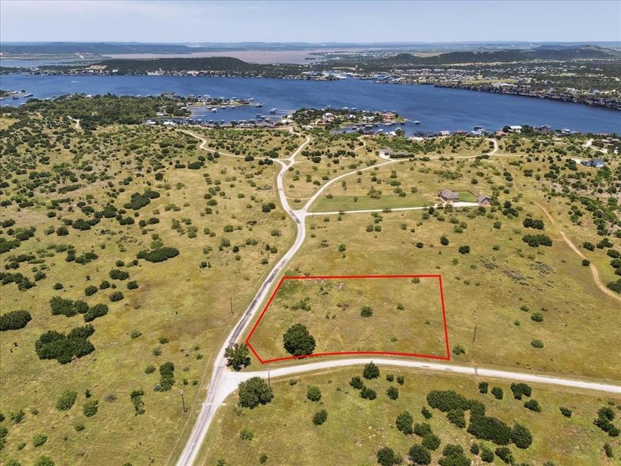 This Prime 2.6+ acre corner lot in the prestigious gated community of Gaines Bend on Possum Kingdom Lake is the perfect opportunity to build your dream home or vacation rental! This property features a level topography, ideal for an easier foundation when building and allowing gorgeous lake views from your second-floor retreat. You’ll love the natural wildlife and the beautiful mature live oak tree on the southwest corner adding character. Enjoy paved road access on two sides for added convenience, and utilities including water, sewer, and electricity accessible from the street.Located just minutes from the community boat ramp, courtesy docks, and rental slips, this lot offers excellent access to lake activities. The Retreat at Gaines Bend allows short-term rentals, providing great investment potential. Residents can also enjoy ATV and golf cart access throughout the community.Don't miss this opportunity to build in one of Possum Kingdom Lake's most sought-after communities!