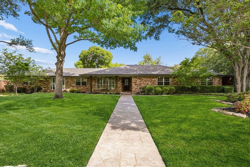 Set on a beautifully treed .402-acre lot in sought-after Northwood Hills, this classic ranch blends timeless charm with thoughtful updates and exceptional outdoor living. Mature trees and lush landscaping create a warm, inviting presence on a quiet, established street.
Inside, neutral tones and a flexible layout deliver a refined, move-in-ready feel. Two spacious living areas, one anchored by a fireplace, offer inviting spaces to gather and unwind. A formal dining room provides an elegant setting for hosting, while the kitchen features abundant storage, updated appliances, and a seamless connection to the main living spaces. A versatile bonus room adds flexibility for a home office, playroom, or additional lounge.
The primary suite offers a private retreat with a walk-in closet and an ensuite bath featuring dual sinks. One secondary bedroom includes its own ensuite, while two additional bedrooms share a well-appointed full bath. A half bath and dedicated laundry room add everyday convenience.
The backyard is a true standout, featuring an expansive covered patio with dual ceiling fans and built-in seating, overlooking a large grassy yard and paved area ideal for outdoor dining, entertaining, or quiet evenings at home. A gated garage enhances both privacy and function.
Major updates include a new roof and gutters (2023), a high-efficiency HVAC system (2024), updated flooring (2023), renovated bathrooms, and kitchen improvements with newer appliances. Additional upgrades include windows, lighting, fencing, and landscaping.
Located in Richardson ISD near top private schools, this home presents a rare opportunity in one of North Dallas’s most established neighborhoods.