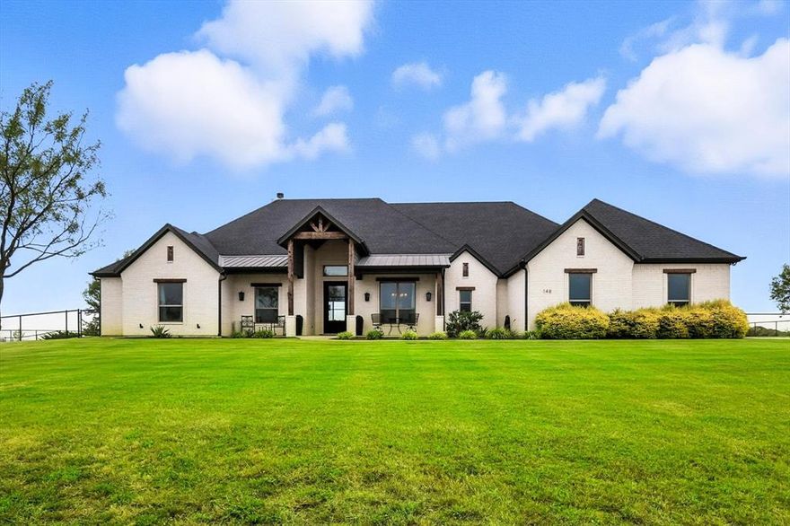 Hilltop luxury in the prestigious Maravilla Vistas awaits. A custom JB Homes masterpiece offers an opportunity to own one of the highest vantage points in Parker County, where panoramic views stretch endlessly across the horizon. Set on just over two acres in the highly sought-after Aledo ISD, this home captures unforgettable sunrises and sunsets from nearly every angle. From the moment you arrive, the welcoming front porch invites you to slow down and take in the sweeping scenery, while the resort-style backyard transforms everyday living into a private retreat. Inside walls of windows flood the home with natural light while just off the entry a private office offers a peaceful and inspiring space to work or study. The main living is so inviting, featuring a pointed fireplace flanked by custom built-ins and accented by exposed ceiling beams that add warmth and architectural character. The open-concept kitchen is the heart of the home, showcasing Thermador appliances, a built-in refrigerator, 3 cm quartz countertops, and a stylish coffee and butler’s bar, all seamlessly connected to the living and dining spaces. The thoughtfully designed floor plan offers four bedrooms and four-and-a-half baths, all on the main level, with each bedroom featuring its own private en-suite, along with a bonus second living space. The primary suite is a true sanctuary, complete with sweeping views, a spa-inspired bath, and a truly expansive walk-in closet. Rich 4-inch white oak floors run throughout the main living areas, while full foam insulation enhances energy efficiency year-round. Upstairs, a bonus room with a large walk-in closet provides flexible space for play, guests, or additional living. A sparkling custom pool, covered outdoor kitchen, and stunning stone fireplace create the perfect setting for effortless entertaining or quiet evenings under the Texas sky. A rare blend with refined craftsmanship and seamless indoor-outdoor living, this is more than a home, it’s a lifestyle.