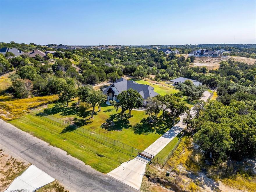 Meet the property that has it ALL! Fully custom COUTO HOME with 1200 SF GUEST HOUSE, 1200 SF SHOP, plus POOL, SPA & OUTDOOR KITCHEN! This fully piped fence property has it's own private electric gated entrance. Gorgeous, grand elevation and landscaping, hand-scraped hardwood flooring and coffered ceiling throughout living, dining and kitchen. You'll get to open up the wall-to-wall double glass doors and bring the outdoor living area in! Extraordinary two toned kitchen design with custom cabinetry, walk-in pantry and true farmhouse sink. This home offers so many additional spaces including a formal dining room, office, media room and upstairs flex room that could be used as additional bedroom with full bath. Primary suite is off the dining nook with complete walk-through to bathroom, closet and in front of laundry access! Highly desirable laundry room with safe room and counterspace galore! Favorite feature is the Dutch door for laundry room! This place is jam packed with EVERYTHING that you need. The outdoor living area is cozy with a wood burning fireplace and full outdoor kitchen set up just outside the primary bedroom. Sparkling pool with multiple waterfalls, fire bowls and deluxe spa, all with smart phone capability.  Additional living quarters sit at the back of the property with a covered patio overlooking the creek. Fully functional with open living area, bedroom, full bath and bar with sink. The 8 foot glass roll up doors are amazing both open and closed! On the other side of the guest quarters, is a fully insulated 30x40 designated shop with a 10 foot electric roll up door and 14 foot ceilings! This home is unbelievable with the amount of amenities already in place. It is FULLY DECKED OUT.  Home still falls under the Builder Warranty. It's your chance to own a piece of property like this...come out and experience what it's like to live within the hills of Eagles Bluff!