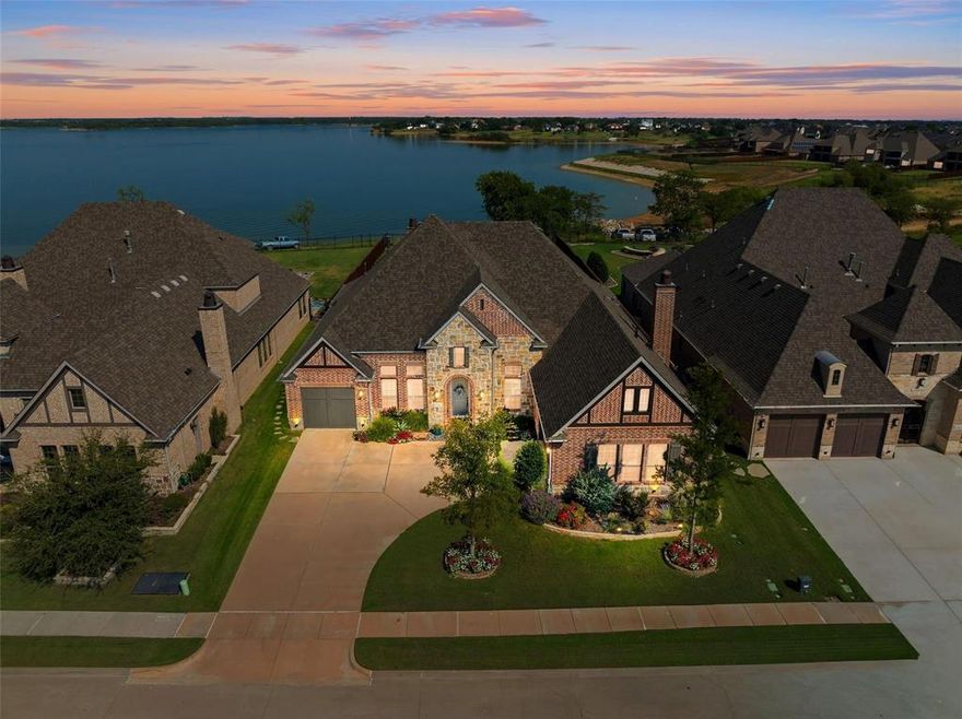 Rare opportunity to own a true lakeside retreat in Waterford Point at The Tribute! This stunning one-story home sits on a .436-acre lot with an unobstructed view of Lake Lewisville and beautifully landscaped grounds. The backyard is perfect for entertaining with a huge covered patio featuring a fireplace and hot tub, all overlooking the lake. Inside, the open-concept design offers a spacious living room with tray ceilings, fireplace, and breathtaking views that flow seamlessly into the chef-inspired kitchen. The kitchen is equipped with Monogram appliances including a double oven, gas cooktop, refrigerator, large island with seating and sink, white cabinetry, decorative backsplash, granite countertops, and a walk-in pantry. The primary suite boasts a bay window sitting area, spa-like bath with dual vanities, jetted tub, oversized shower, and a custom closet. Two secondary bedrooms each have private baths, plus a formal dining room, office, and oversized laundry room with sink and space for a second refrigerator. The mudroom, epoxy-coated garage with EV charger, and abundant storage add everyday convenience. Plantation shutters and luxury vinyl flooring throughout elevate the home’s style. As part of The Tribute’s award-winning community, enjoy two resort-style pools, a children’s splash park, miles of scenic trails, a fitness center, clubhouse, and more. A vibrant new marina and lakeside park are underway and set to open Summer 2026. Ideally located near FM 423, TX-121, and the Dallas North Tollway, you’ll have quick access to Frisco, Plano, Dallas, shopping, dining, and top-rated schools. This is lakeside living at its finest—your retreat awaits!