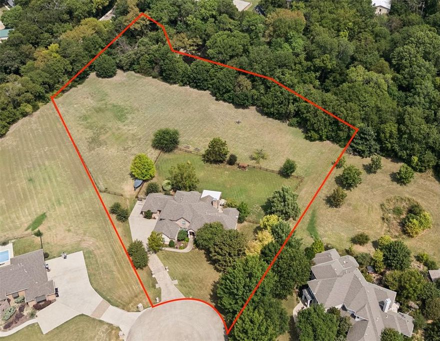 Situated on just over 3 private acres backing to a tree lined creek in Lovejoy ISD, this one owner custom home offers space, flexibility, and true Texas privacy with the convenience of nearby shopping and dining just minutes away.
With 5 bedrooms, 5.5 baths, and two primary suites, the layout is ideal for multigenerational living. The main level secondary primary features private exterior access, perfect for a mother-in-law retreat or long-term guests. A dedicated office with built ins and a Murphy bed adds functional versatility.
Light filled living spaces, extensive built in cabinetry, and abundant storage define the interior. The kitchen features a gas cooktop, walk in pantry, generous prep space, and seamless flow for entertaining. Both primary suites offer spacious walk-in closets with custom built in drawers and cabinetry.
Outdoors, enjoy a covered patio with TV setup, expansive fenced yard with additional small dog safe fencing, and approximately 125 yards of open space beyond the fence ideal for practicing golf, adding recreation, or simply enjoying the wide-open sky. A 10x16 storage shed and rare 3.5 car garage provide added utility.
Extended flatwork, blown cellulose insulation, horses and chickens permitted, and close proximity to Trinity Trail access and the Highland Park boat ramp complete the offering.

Acreage. Creek. Flexibility. Privacy.