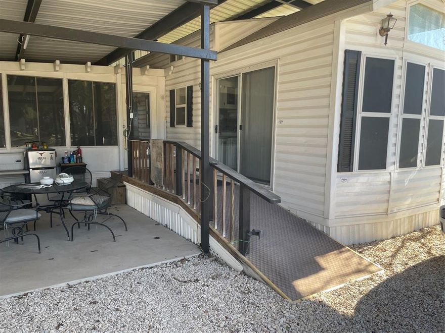 Very nice home in the Whitney Resorts which has over 300 acres of beautiful land that has hiking trails and picnic areas close to the lake.  This is an 55 and over community.   This property is similar to a townhome or condo as you own the improvements just not the land.   Land is leased from Whitney Resorts.   The bonus is you have access to the trails, chapel, community center, community pool, large event center, large dog park and an awesome dog wash facility.  The home is an appx 14 x 40 mobile home, with 2144 sq feet of covered awning covering the home, patio, and rest the to park.   The nicely remodeled home has a large master room and master bath that was an add-on to the home itself.  The second bedroom makes a perfect office, the kitchen has lot's of organized storage and really cute.  The dining opens up to the kitchen and the living area.   Living area is roomy with lots of windows.    The master and the living area each have an additional mini split ac along with the solar screens all help with the electric bills.    Walk out the patio door to a ramp that goes to the patio and parking area.    In the side yard is an appx 12x14 workshop with electric that also houses the washer and dryer with a water heater and window ac unit.  This little property has a lot to offer.   Bring your pontoon boat and park under the awning with your vehicles.    This property includes a community dumpster therefore no big garbage trucks driving throughout the community.   No worries about a septic, the community has its own septic and water source.    Less for you to worry about or maintain, which saves you money and more time to go play.