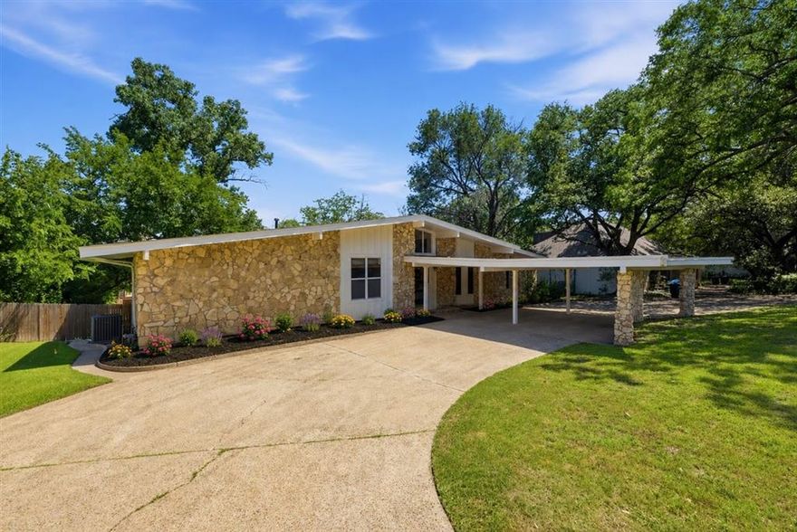 Tucked beneath a canopy of mature trees in an established Fort Worth neighborhood, this beautifully updated home blends striking architecture with warm, modern design. Set on an oversized lot with an expansive front yard and a backyard built for entertaining, the property offers a rare combination of privacy, style, and outdoor living. Inside, soaring vaulted ceilings, abundant natural light, and an open-concept layout create an airy, inviting feel throughout the main living spaces. The fully remodeled kitchen features crisp cabinetry, quartz-style countertops, stainless steel appliances, sleek vent hood, subway tile backsplash, and generous prep space that flows seamlessly into the dining and living areas. A dramatic double-sided fireplace serves as the centerpiece of the home, adding character and ambiance between the living spaces. The spacious primary suite includes a spa-inspired bath with dual vanities and an oversized walk-in shower wrapped in timeless natural stone finishes. Fresh paint throughout gives the home a clean, move-in-ready feel, while the recently installed AC offers added comfort and peace of mind. Step outside to enjoy the impressive 14x20 elevated deck overlooking the massive backyard shaded by mature trees — perfect for entertaining, grilling, or relaxing evenings outdoors. Additional exterior improvements include a French drain and new landscaping installation scheduled for the week of May 25, further enhancing the beauty and functionality of the property. With its unique architectural style, oversized lot, modern updates, and exceptional indoor-outdoor living, this Fort Worth gem is one you won’t want to miss. Schedule your showing today!