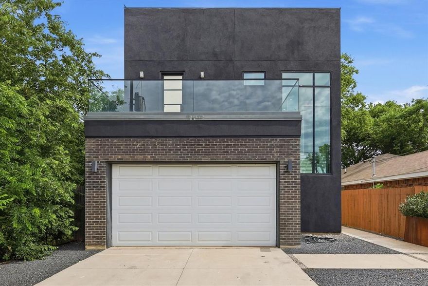 Architect designed modern in Trinity Groves offered at $560,000. True two story home with 2,442 sq ft featuring garage, chefs kitchen, living, laundry, and half bath on main level, plus 3 bedrooms and 2 full baths upstairs.

Open concept living anchored by dramatic floor to ceiling concrete plaster feature wall with custom electric water vapor fireplace and matching vent hood. Kitchen features waterfall Calacatta quartz island seating 4, full height white European cabinetry, dark marble backsplash, under cabinet lighting, gas range, and stainless French door refrigerator, all conveying.

Floor to ceiling black framed glass with approximately $100k replacement value and sliders with blackout drapery open to covered concrete rear patio with full outdoor sectional, mature 7 ft magnolias, white Rose of Sharon shrubs, and $3k custom shed. Primary suite offers private rear balcony, massive walk in closet with custom built in organization system, blackout drapery, freestanding soaker tub, frameless glass shower with marble inlays and bench, dual Calacatta veined quartz vanities, separate water closet, and large format porcelain.

Front bedroom includes second private balcony and custom built in Murphy bed with bookshelves configured as office guest room. Third bedroom bright and flexible with ceiling fan. Real hardwood upstairs, wood look porcelain downstairs. Fully foam insulated verified in 2023 purchase docs, 6 inch thick perimeter walls, full stucco exterior, rain gutters with guards, split AC per floor, custom iron door with black restucco on upper patio, brand new water heater, $6k garage gym flooring, and $1k EV charger.

Over $30k landscaping includes custom Corten steel garden boxes, mature holly hedges, sprinklers, drip irrigation, fully fenced yard with dual gates, and dog door in laundry. Just 5 minutes from Downtown Dallas.