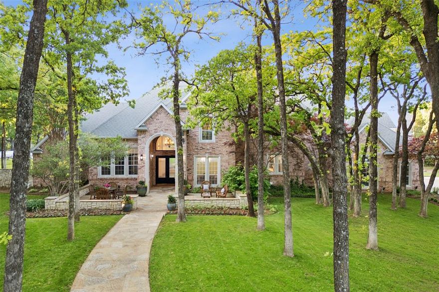 Tucked away at the end of a quiet cul-de-sac in the highly sought-after community of Southlake, this 5,495 square foot estate sits on a beautifully treed 1-acre lot with no HOA and offers a rare blend of privacy and resort-style living. The home’s stunning curb appeal is highlighted by a grand front patio and striking double doors that welcome you into a thoughtfully designed interior filled with rich wood floors, natural light and soaring ceilings. A private office with illuminated built-in cabinetry and a coffered ceiling provides the perfect work-from-home retreat, while the formal living features lit glass shelving and an elegant fireplace. The spacious primary suite is a true sanctuary, with a sitting area, gas fireplace, and wall of windows with serene pool views, direct backyard access, a spa-inspired en-suite bath with soaking tub, separate vanities and shower, and an expansive walk-in closet. The gourmet kitchen offers honed granite counters, a built-in fridge, new Thermador gas cooktop, double ovens, warming drawer, two wine fridges, and flows seamlessly to the family room with stone fireplace. Entertain with ease in the main floor game room with built-ins and a backyard door, or step outside to your personal paradise—featuring a sparkling saltwater diving pool, a large covered patio with built-in grill, a charming pergola, fire pit, and a fully lit sports court equipped for basketball, pickleball, and even roller hockey with installed boards and nets. Upstairs, beyond the grand staircase, discover four additional bedrooms—two with en-suite baths and the other two connected by a Jack and Jill layout—as well as a built-in study nook, a generous bonus room, and walk-in attic storage.  This exceptional property offers the ultimate Southlake lifestyle, on a spectacular lot, with unmatched recreational amenities.  Close to world class shopping, dining, just 15 west of DFW Intl Airport, with award winning Carroll ISD.
