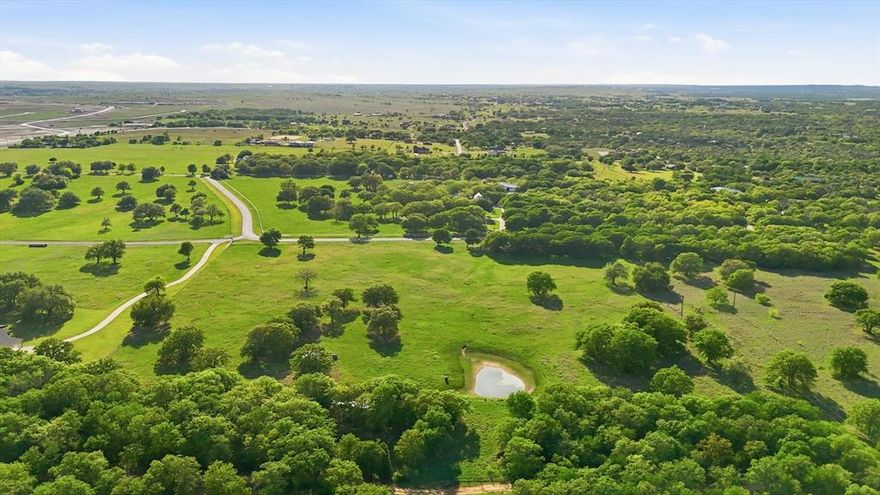This is a rare opportunity to secure one of Aledo’s most exclusive acreage homesites designed for those who value privacy, space, and a refined, unrestrained way of living. Tucked quietly behind the curve of Kelly Road, River Ranch Road is one of Aledos best-kept secrets - a if you know, you know enclave of only 8 estate-like residences that lead back to the Clear Fork of the Trinity. With limited restrictions in place, this property offers an increasingly rare level of freedom, inviting you to bring horses, livestock, and create a legacy estate tailored entirely to your vision. Set across 13 picturesque acres, the land unfolds with a sense of quiet sophistication, featuring mature trees, a serene pond, and a landscape that feels both curated and untouched. A pipe fence lines the front entry, while full perimeter fencing is already in place. With a water well and electric established, the groundwork has been thoughtfully laid for you to begin building without delay. Surrounded by distinguished 10+ acre estates and beautiful custom homes, this property offers a level of privacy and prestige that defines luxury country living. This is where architecture meets land and where intention meets opportunity, providing an extraordinary setting to design and build a home that is both timeless and deeply personal. This property offers seamless access without sacrificing privacy. As Aledo continues to see strong growth and demand for acreage living, opportunities like this remain limited, making this not only a remarkable place to build but also a compelling long-term investment.