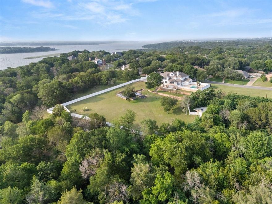 Rare 7,000 sqft home on over 5 acres in Woodway, TX. This is where luxury meets outdoor adventure.
Tucked behind the mouth of the Bosque River in one of Woodway's most coveted addresses, this extraordinary estate makes you feel like you've arrived and escaped all at once. Giant front doors open into a sunlit living room with soaring ceilings and oversized windows framing sweeping nature views. An elevator anchored like architectural art signals immediately that this home was built without compromise. Set on 5.49 acres, this 7,270 SF masterpiece was built for those who refuse to choose between refined living and wide open adventure. Every room floods with light and those legendary Woodway sunsets. The downstairs primary suite features one of six fully renovated bathrooms, each finished to turn a daily routine into a daily indulgence. Upstairs, three additional bedrooms and bonus spaces offer room to grow. A secondary primary suite on the opposite wing gives guests their own world entirely. A resort style backyard features a sparkling pool and sports court backed by your own private slice of nature. A massive shop sits tucked into the treetops, ready for big projects or every tool and toy the property demands. The den anchors the home with a wet bar and pool table. Nobody leaves early. The office conceals a hidden room behind one of the shelves, adding a sense of wonder that fits the adventure of this property. The chefs kitchen delivers with full sized built in refrigerator and freezer. Ascend by staircase or elevator to a purpose built third floor movie room, plus a screened in porch perfect for a plant room or quiet retreat. The new owner can subdivide and build additional homes, making this a rare investment play in one of Woodway's most desirable pockets. Zoned to Midway ISD. This is a lifestyle, a legacy, and a once in a generation opportunity on the Bosque.