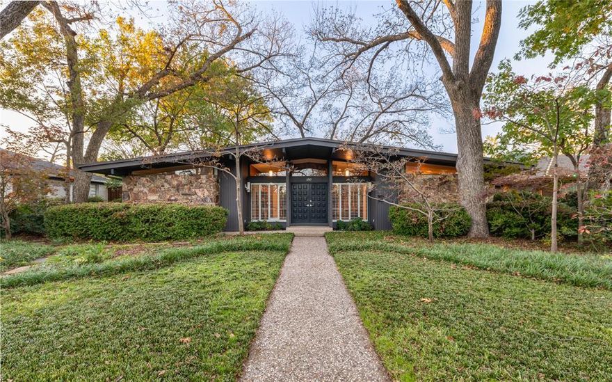 Nestled on a beautifully shaded .23-acre lot with a canopy of heritage Pecan and Red Oaks, towering Dogwoods, Crepe Myrtles and Japanese Maples, this 2,196 sq ft, 1964 custom-built Ju-Nel Mid-Century Modern home has been meticulously cared for by the original family. Inside, the foyer leads you to bedrooms down hallways left and right, and draws you forward to the heart of the home.

Step into the sunken living room with walnut-paneled walls and abundant natural light, where the fireplace anchors the space on one end and views stretch through the living room to the large, grassy backyard on the other end. Walnut beams stretch across the expansive room. To the left is the dining room and kitchen, perfectly framed with the living room's walnut bookcase. Also overlooking the backyard, the kitchen is finished with warm walnut cabinetry plus stainless-steel countertops and appliances, a tasteful blend of character and livability. Just beyond the kitchen, is a bonus room adding approximately 500-sq ft of additional living area to the home.

Welcome home to this thoughtfully preserved mid-century modern home where architecture, light and layout combine with comfort and practicality — ready for the next chapter.