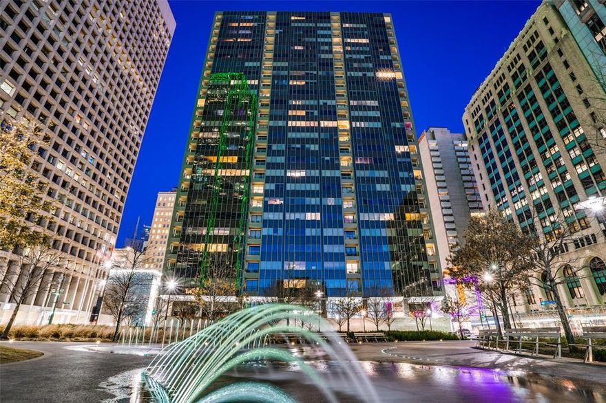 This spacious contemporary condo in the heart of Downtown Dallas is perched on the SW corner of the 12th floor.  Enjoy views of Civic Garden Park, the Bank of America Tower, the Calatrava Bridge and beautiful sunsets.  Relax on the covered terrace while soaking in the views.  The spacious living room offers plenty of space for living and dining areas.  There is also another room that would be suitable as a den or home office and it has its own half bath.  Or, add a door and use it as a third bedroom.  The closet for the full size side by side washer & dryer is also located in this room.  The primary bedroom offers a large walk-in closet as well as another generous closet.   HVAC was replaced in 2020.  Side by side parking spaces 78 & 79 in the underground garage will convey.  There is also a storage room down the hall (#1217 with approx. 30sf) that coveys.  The Metropolitan features a Sixth floor community deck with pool-spa, outdoor living area & grilling area.  Also on six, you'll find the conference room, community room, gym & guest room.  Elsewhere in this amenity rich building there is a hobby room & screening room.  The Concierge desk is staffed 24-7 & will accept your deliveries.  Walk to the AT&T Discovery District, the flagship Neiman Marcus, Dallas Arts District, Klyde Warren Park, many restaurants, retailers and hotel lounges.  DART rail is just two blocks away for transport to DFW, Love Field & the greater Dallas area.  The HOA does NOT allow Airbnb, VRBO or similar short term rentals.  Also available for minimum one year lease @ $2950 per month including electric, water & two secure parking spaces in covered garage (see MLS #21055165).