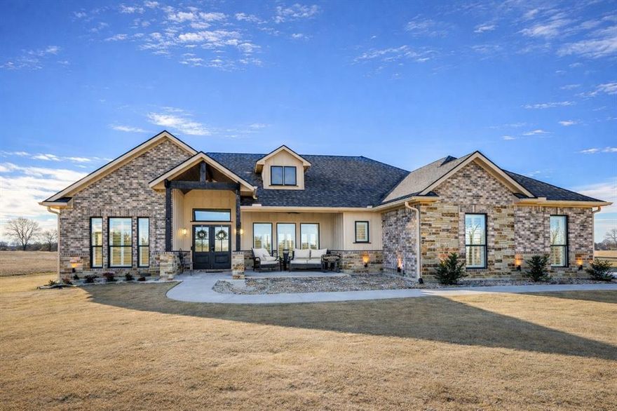 Gorgeous single-story luxury custom home on one full acre near the 65-acre Lake Bonham. Located in a quiet, established neighborhood, this beautifully designed home offers peaceful living with easy access to boating, fishing, and outdoor recreation—while still just minutes from downtown Bonham amenities. From the front porch, enjoy a stunning view of the lake, creating an inviting space to relax and take in the scenery.

The heart of the home features a large open-concept living, dining, and kitchen area, ideal for entertaining. A stunning natural stone fireplace with gas logs anchors the space, highlighted by a pop-up tray ceiling and custom finishes throughout. The kitchen is complemented by an oversized walk-in pantry, and the laundry room is conveniently accessed through the primary suite’s walk-in closet—an exceptional and highly functional design detail.

The private primary suite offers a spacious retreat with a luxurious en-suite bathroom featuring a large walk-in shower with a seated bench for two, separate vanities, and an expansive walk-in closet. Two secondary bedrooms are thoughtfully positioned on the opposite side of the home, providing excellent privacy for the primary suite.

Outside, a huge concrete driveway provides ample parking, easily accommodating a number of vehicles and offering plenty of room to park a boat or RV—perfect for lake living and entertaining guests.

Walk down South Shore Lane to fish from the shoreline, collect mussel shells, enjoy sandy areas, or play in the water. When lake levels are low, you can stroll along the shoreline. The property also offers convenient access to two free public boat ramps—the North Ramp and the popular Park Ramp with a playground, camping, and nearby store—making this a favorite summer destination.

This exceptional property offers space, privacy, and breathtaking views—delivering a true lake-area lifestyle rarely found at this level of quality.