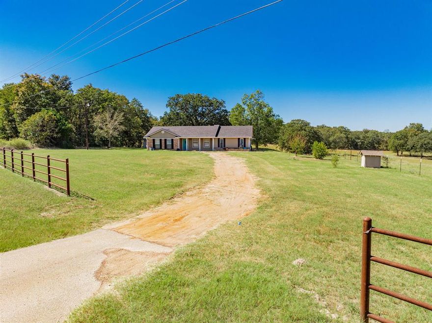 Enjoy country living on 2+ acres of open Texas countryside! This single-story brick home offers space and privacy just minutes from downtown Athens. A covered front porch welcomes you inside to a generous living area with multiple windows for natural light and direct flow into the dining and kitchen spaces. The kitchen features SS appliances, extensive cabinetry, and abundant counter space for everyday function and meal prep. A dedicated laundry room adds practical convenience. The primary suite provides exceptional space, recessed lighting, and a ceiling fan for comfort, along with a walk-in closet built for organization and a full ensuite bathroom with a double vanity and tub-shower combination. Outside, an expansive wooden deck beneath mature shade trees provides the perfect spot to take in the wide-open landscape and rolling views. A detached structure offers additional storage or workspace flexibility. The property operates on a private well and septic system, offering self-sufficient living with no city water costs. Located approximately an hour drive southeast of Dallas, Athens combines small-town charm with access to shopping, dining, and medical services. Enjoy the natural beauty of East Texas while remaining close to Cedar Creek Lake and numerous parks, trails, and recreation areas. Claim Your Piece of Texas!
