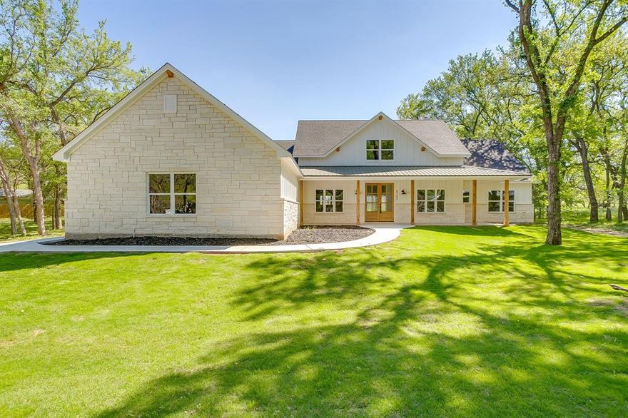 Welcome to 6705 Westover, a beautifully designed custom farmhouse nestled within the highly sought after & amenity rich community of Pecan Plantation in Granbury, TX. From the moment you arrive, the striking white exterior with bold black trim sets the tone for a home that is equal parts stylish, warm & thoughtfully crafted. Inside, gorgeous luxury vinyl plank flooring flows throughout the main living spaces, offering both durability & high end appeal, while the open concept layout creates an inviting atmosphere ideal for both everyday living & entertaining. A dedicated home office provides the perfect work from home setup or flexible space, thoughtfully positioned for privacy. The heart of the home is the kitchen, featuring an abundance of custom cabinetry, a large center island with Carrara quartz countertops, a timeless custom backsplash, & a window above the sink overlooking the backyard that fills the space with natural light. The split bedroom floor plan offers comfort & privacy, with the primary suite serving as a true retreat complete with spa inspired ensuite bath featuring a luxurious soaking tub, separate walk in shower with custom tile work, refined finishes, and an oversized primary closet with custom built ins. Step outside to the covered back patio, an ideal space to relax or entertain while enjoying the peaceful surroundings, with frequent sightings of deer roaming nearby lots adding to the serene setting. Located within the gates of Pecan Plantation, residents enjoy access to two championship golf courses, multiple on site restaurants, a private grocery store & gas station, parks, walking trails, marina & dock access on Lake Granbury, & Brazos River frontage, all contributing to an exceptional lifestyle. 6705 Westover offers the rare opportunity to own a thoughtfully designed home in one of the Metroplex’s most desirable master planned communities, combining quality craftsmanship, natural beauty, & resort style amenities in one exceptional property.