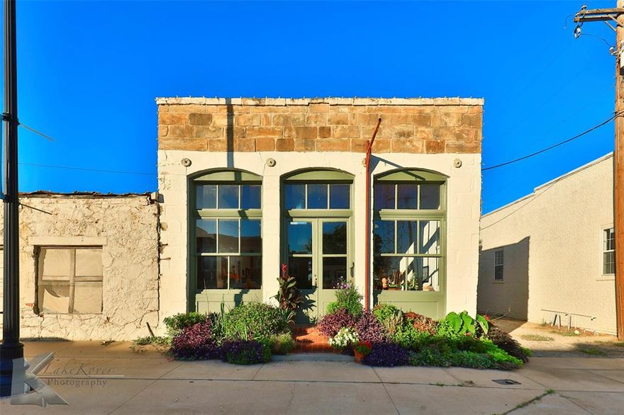 Come be a part of the growing excitement of downtown Cisco! Great opportunity to own this historic building across from the original Conrad Hilton building. At one time this was a Coke-a-Cola distribution location. If you are a history buff, you will enjoy knowing that Captain George Whiteside lived upstairs at one tine and had a saloon downstairs.  Oh, if these walls could talk!  Currently grandfathered & being utilized as a personal residence with 2 bedrooms, an office or reading room & 2.5 baths, this building provides endless business opportunities including a bed & breakfast, VRBO, restaurant, studio or boutique. This building has all the charm with original stone walls that also provide good insulation, an entire front wall of windows with amazing natural light, original wood ceilings, and cabinetry with bar seating. Old garage has character & could be additional patio seating. Plenty of parking along Conrad Hilton and take a walk to nearby museum, wineries, brewery, and boutiques. Don't miss this unique building in a prime location! Must be pre-approved to view. Property restricted to keep character and architecture of exterior, front of building.