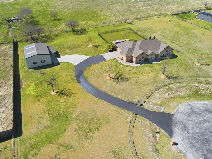 Nestled in the peaceful Heritage Creek North neighborhood of Decatur, Texas, this beautifully maintained four bedroom, two bath home offers the perfect combination of comfort, space and country living. Situated on a large two-acre lot, you will enjoy wide open spaces with room to roam. Split bedroom plan offers privacy. In addition to the four bedrooms, there is a large office or study with double French doors. The spacious primary bedroom features an oversized bathroom with jetted tub and large walk-in shower. The kitchen features custom cabinetry, granite countertops, and a beautifully tiled island offering style and functionality. Adjacent to the kitchen and dining room is the spacious living area which features a stone, wood-burning fireplace. Flooring is a combination of stylish tile and Pergo laminate throughout with new carpeted bedrooms. Back patio also has wood-burning fireplace. There is a spacious two-car garage with built-in cabinets. Owners have built a large, detached 1200-foot metal building ideal for shop and RV storage with 12 foot overhead doors. Expansive two-acre lot is fenced with electric front gate and has additional wrought iron fencing which separates back yard from remainder of acreage.