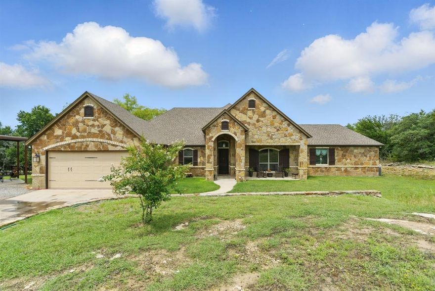 Welcome to your dream home located in the heart of Mountain Lakes Ranch development, Bluff Dale Texas. This stunning 4-bedroom, 3-bath custom-built home with a dedicated office blends thoughtful design, comfort, and functionality—offering everything you need for modern country living. Step inside and be greeted by 10’ ceilings and durable concrete floors that flow throughout the main level. The expansive wall of windows in the living area captures breathtaking hill country views and fills the open-concept space with natural light. The gorgeous knotty alder cabinetry, granite countertops, center island with breakfast bar seating and walk-in pantry make the kitchen a true centerpiece for gathering and entertaining. The spacious primary suite is located on the first floor and features sweeping views, a luxurious ensuite with garden tub, walk-in shower with seat, dual vanities, and ample closet space. Two additional bedrooms are also on the main level, while the fourth bedroom upstairs includes dual closets and a private full bath—perfect for guests or multi-generational living. Function meets convenience in the large utility room, with lots of storage and a custom tiled pet shower. Outside, enjoy the peace and possibilities of country life. The property includes a 30x40 insulated shop with windows, two walk-through doors, and a 10’ roll-up—ideal for projects, hobbies, or extra storage. A 3-sided barn offers shelter for your animals, and with goats, a donkey, and a horse already calling it home, it’s perfectly suited for hobby farming or simply enjoying the ranch lifestyle. Don’t miss the opportunity to own this exceptional home that offers space, scenery, and endless potential in the picturesque community of Bluff Dale.