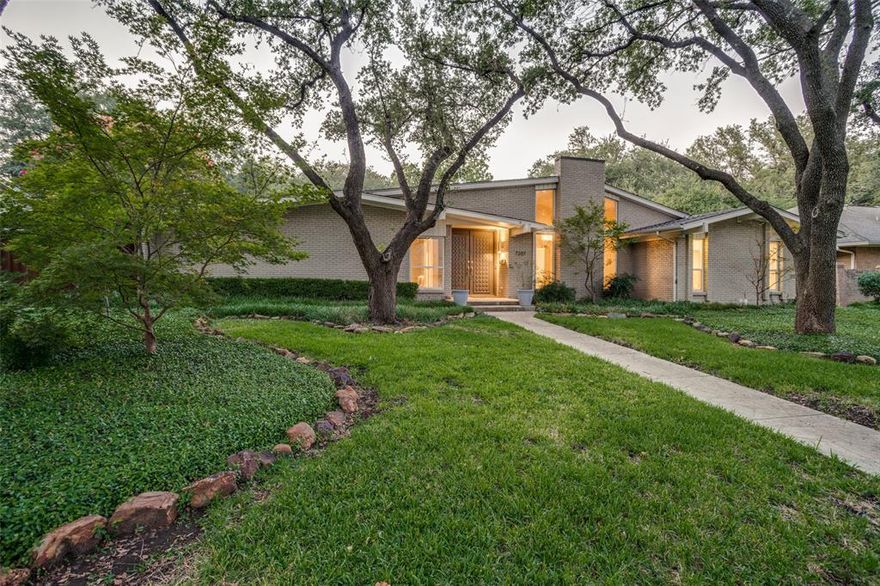 Mid-Century Modern charm meets flexible family living in the highly sought-after Windsor Park neighborhood of Preston Hollow. Nestled on a stunning, mature tree lot, this spacious 5-bedroom, 3.5-bath home offers iconic architectural style, clean lines, and a functional layout on one of North Dallas’s most picturesque streets. Built with the hallmarks of Mid-Century Modern design, the home features an open floor-plan. Inside, you’ll find multiple living and dining spaces, ideal for both entertaining and everyday life. The formal dining room is generously sized, while the family room with a classic brick fireplace offers warmth and comfort. A wood-beamed breakfast room connects to the open kitchen. The home’s layout provides privacy and flexibility. On one side, two bedrooms share a full bath, creating the perfect guest suite or retreat. One bedroom includes direct access to the backyard. On the opposite wing, the primary suite and two additional bedrooms offer separation and space for the whole family. The primary bathroom is a standout, featuring a standalone soaking tub inside a spacious walk-in shower, delivering a luxurious, spa-like atmosphere. The secondary bedrooms are connected by a Jack-and-Jill bath, and there’s a convenient half bath for guests. Additional features include a private office with French doors, perfect for working from home or a quiet creative space. Throughout the home, natural light and clean architectural lines highlight the thoughtful design and timeless appeal of the Mid-Century era. A large, tree-covered lot shaded by a canopy of mature oaks. Whether you envision a peaceful retreat, lively outdoor entertaining, the home offers endless potential in a serene environment. Located in Windsor Park, one of Preston Hollow’s most established and sought-after neighborhoods, this home combines vintage character with modern livability.
