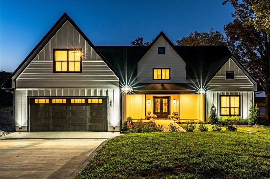 Stunning New Construction! Nestled in an exclusive and private neighborhood, this breathtaking 5 bedroom, 4 bath home offers everything you could want for luxury living. With a wall of windows revealing beautiful lake views, this home features two living areas and two laundry rooms for the ultimate comfort and convenience. Inside enjoy the warmth of engineered wood floors and cozy gas log fireplace. The gourmet kitchen is a chef's dream, boasting quartz countertops, two dishwashers, an ice machine and a beverage refrigerator - ideal for entertaining. Step outside to your huge covered porch, surrounded by professional landscaping and a custom fire pit. The double boathouse featuring a sun deck is perfect for soaking in the scenic surroundings.