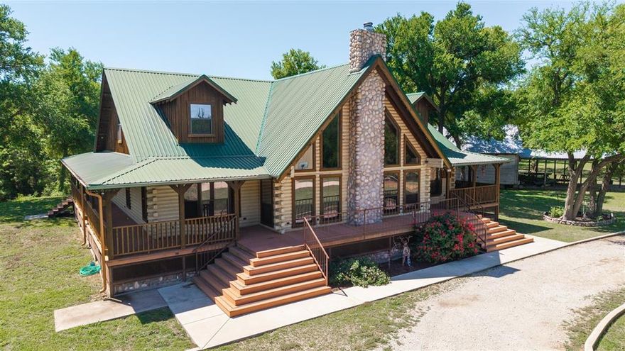 This property is so secluded, no one will ever find you. Located at the dead end of CR 215, sits this beautiful two-story custom-built log home on the banks of the Jim Ned Creek. The setting is beautiful with large Elm & Pecan trees, the house has a large, covered wrap around porch which is a perfect place to sit, relax and enjoy the quiet and park like setting. This beautiful custom-built log home sits on the bank of the Jim Ned Creek which is one of the main tributaries to Lake Brownwood. This home features 4 bedrooms, four & half bathrooms, large den, dining, kitchen combination with vaulted ceilings. Downstairs has 2 bedrooms, two & half bathrooms, den has wood burning fireplace insert beautiful kitchen with island bar, granite counter tops, fully equipped kitchen with large gas cookstove, built-in-ice maker, large utility room which open to the covered porch, double ovens, washer and dryer connections, large pantry. There are beautiful hardwood floors, carpet in bedrooms, solid wood ceiling and walls. The upstairs has 2 bedrooms, 2 bathrooms, loft area which open to outside covered balcony. The loft is ideal for a second living area, office area or overflow bedrooms. There are two heating and cooling units, 2 septic tanks, Brookesmith water, irrigation system for the yard that pulls water from the Jim Ned Creek. The house is built approximately 4 feet above ground level; there is a flood elevation certificate showing the house is above flood level. There is a detached all metal workshop with 1,500 square feet of area, a 720 square foot attached canopy, there is a shower in the barn. There is an older house that is used for large group cooking and over flow bedrooms.