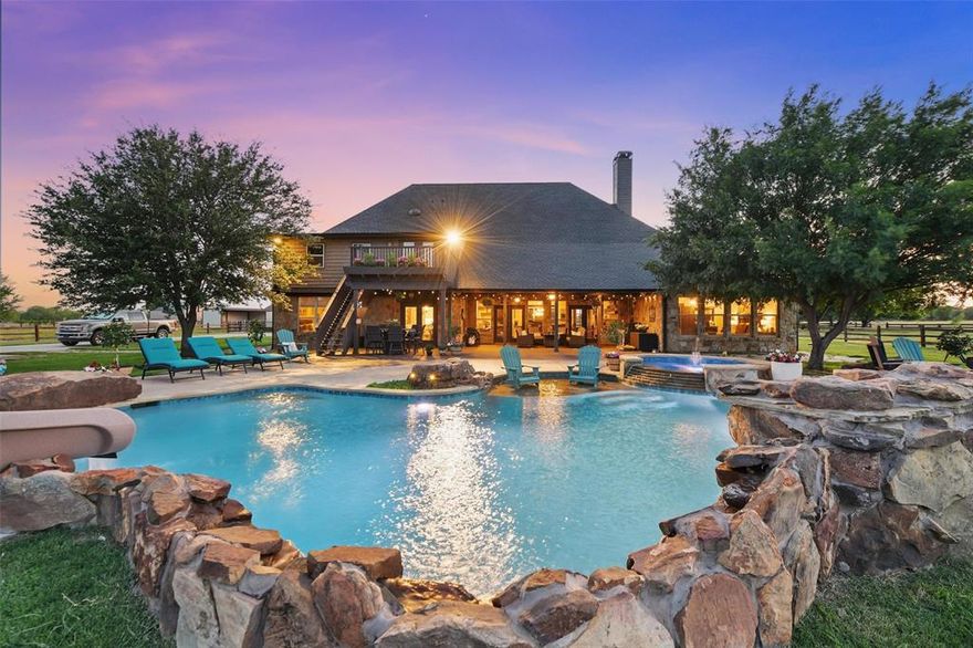 Your Texas Dream Life awaits in this ultimate ranch retreat! Situated on over 28 acres at the end of a cul de sac, this ag-exempt estate is the epitome of country living yet close to it all! The custom ranch house is warm and inviting with vaulted, open beamed ceilings, floor to ceiling rock fireplace, stained concrete flooring, and four en-suite bedrooms, all on the main floor. Open by design, the effortless floor plan showcases a gourmet kitchen with custom rock range, Dacor appliances, built in wine refrigerators, quartz countertops, farmhouse sink & reverse osmosis water system. Upstairs is the dedicated office, game room, media room with Sony projector and movie screen, exercise or craft room. The backyard oasis is resort quality with an in-ground custom pool with waterfall, grotto, slide, spa, sun deck, and Sonos surround sound speaker system. Huge 30X50' shop that can fit your RV or boat. Seasonal pond that is perfect for throwing sticks for the dogs and an amazing 150X254' roping arena with sandy loam. There are three lean-twos with five stall runs and automatic water dispensers. The impressive tree-line leads into a back wooded area with access to Denton Creek, where you can trail ride and fish. Generac back up too! It is becoming increasingly difficult to find this caliber of home, land, amenities and prime location in North Texas. The seclusion of this property is never going to be compromised with unknown development. With all of the hustle and bustle, the tranquility of coming home to your own private paradise refreshes the soul and is a lifestyle that dreams are made of. Make it yours.
