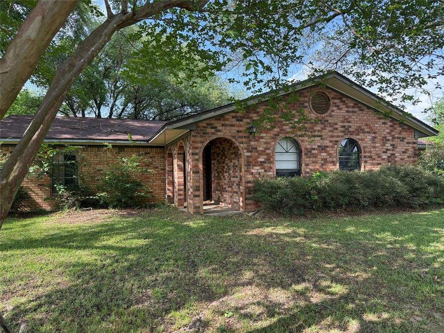 Timeless treasure full of potential. This 3-Bedroom, 2-bath home offers spacious living room with a formal dining room, plus a converted garage featuring a workshop, private work room, office or flex space with half bath. Unique oval entryways with brick trim, vintage lighting, beautiful chandelier with oak built ins.  Rare opportunity with lots of shape to create from.  Step outside to a huge, fenced backyard shaded by mature trees, creating a peaceful setting with room to enjoy. Bring your ideas and personal touch to make this special property shine. Corner lot with storage.