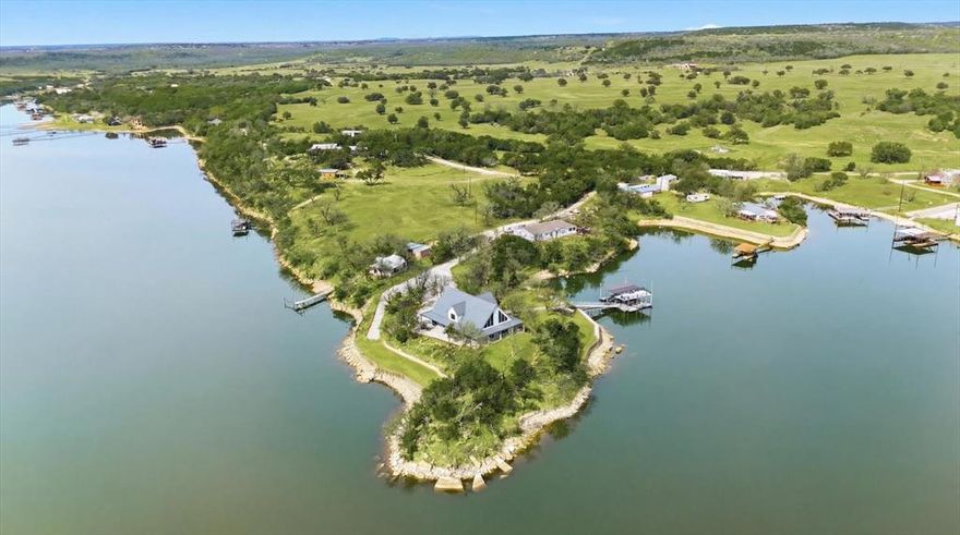 Set on the peaceful west side of PK,  this property sits on 1.5 acres of secluded  waterfront providing outstanding privacy, calm DEEP waters and expansive open lake views.  The property is thoughtfully arranged to highlight outdoor living with tiered terraces, shaded gathering areas and stone pathways that lead naturally to the waters edge, a multilevel private dock serves as the centerpiece of lake life.  The dock features 2 boat slips, 1 personal watercraft slips & generous covered, open areas designed for relaxing or entertaining family & friends,  Completed in 2022, the custom built home offer a modern open layout that connects seamlessly to the outdoors.  The main living area features soaring ceilings, expansive windows framing the lake, statement lighting and a centrally located wood-burning stove.  The chef's kitchen is designed for gathering after long days on the water & includes premium stainless steel appliances double refrigerator & ovens, abundant cabinetry & ample storage.  The main level includes a spacious primary suite with a soaking tub, walk-in shower & separate closets, along with a guest bedroom full bath & utility room.  Upstairs, a loft overlooks the living area accompanied by 2 additional bedrooms, a full bath and generous storage.  An unfinished attic space offers flexibility for future expansion.  This private peninsula property delivers a rare opportunity to enjoy P K Lake at its finest- combining privacy, modern luxury, protected waterfront & spaces designed for true lake living.