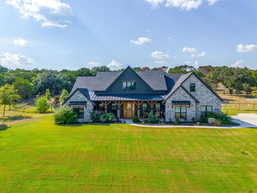 Welcome to Your Dream Modern Farmhouse Retreat in the Brock ISD. As seen on the Emmy nominated and Telly award winning TV show The American Dream. Nestled on a serene 2-acre lot filled with mature trees, this custom-built home offers the perfect blend of luxury, comfort, and convenience. Located just minutes from Fort Worth and all the amenities of Weatherford, this exceptional home sits within the exemplary Brock school district, making it an ideal location for families seeking both tranquility and top-rated education. As you step inside, you’re greeted by high-end finishes throughout, including striking quartzite kitchen countertops, top of the line appliances including an induction cooktop, wood look tile flooring, designer lighting, beams and premium fixtures. The heart of the home is the spacious kitchen, where a stunning picture window over the farmhouse sink frames views of the lush landscape, flooding the space with natural light.The thoughtfully designed layout includes 4 bedrooms total; 3 bedrooms and two and a half bathrooms on the main level, along with a dedicated office, perfect for working from home or managing daily tasks with ease. Upstairs, you’ll find the fourth bedroom, complete with its own full bathroom—ideal for guests, a media room, bonus room or a private retreat. Step outside and discover your very own backyard paradise. The meticulously landscaped gardens and expansive green space set the stage for outdoor living at its finest. Cool off in the custom inground gunite pool with spa, then relax or entertain in style under the covered back patio, complete with a fully equipped outdoor kitchen. And don’t forget the large, welcoming front porch—a peaceful spot to enjoy your morning coffee or a Texas sunset. Plenty of room for a shop. This one-of-a-kind property is more than a home—it’s a lifestyle.