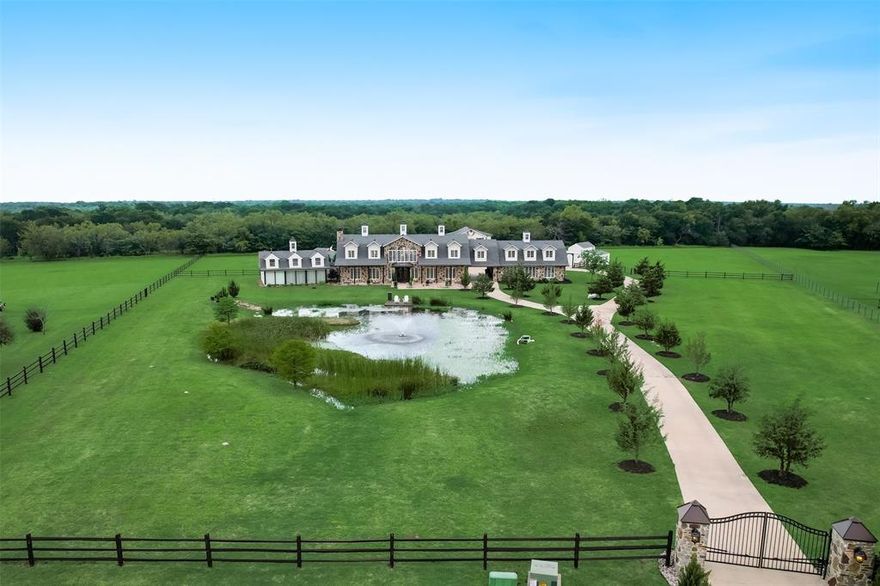 Modern Hill Country Estate is gated & on approx 5 acres w- stocked pond. The estate combines rustic & luxury w-exposed wood beams, shiplap vaulted ceilings, stone accents & classic finishes. Gourmet kitchen offers lots of charm, custom cabinets, Quartz counter tops, Farm sink, Frigidaire refrigerator, 6 burner gas range w-double ovens & lots of storage. Cozy family room w- stone fireplace & spacious office. The Billiards Room was meant for entertaining w-bar, & beer tap. Luxurious master suite has a fireplace, electric shades, marble shower & soaking tub. Upstairs, a 2nd master suite w-fireplace & walk in closet, spacious guest rooms, living area w-built in bookcases & game room leads to an impressive theatre room. The back yard experience offers a beach pool w-waterfall, covered outdoor living w-grill & bar area, separate hot tub deck, multiple sunning areas, cabana bath & outdoor shower.  Additionally offered is a 2 stall barn, 900 SF workshop & 900 SF apartment & greenhouse.