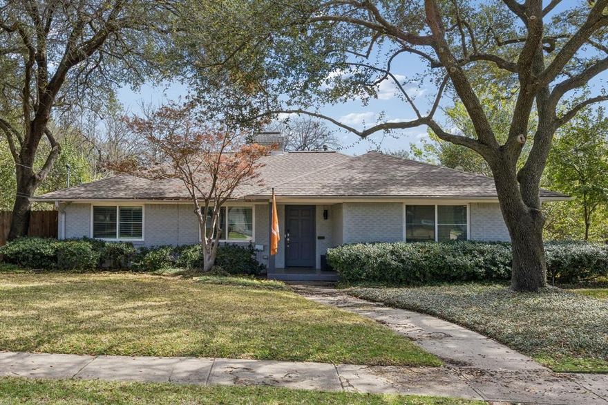Classic and clean, and perfectly positioned on a large corner lot, this Ridgewood Park ranch-style home is truly special. Ideal in its location and floor plan, the two bedrooms (plus a separate office space with handsome wall paneling!) and living spaces have hardwoods and lots of light throughout. Anchored by a gas log fireplace and a large window overlooking the roomy backyard deck (turf putting green included!), the open-concept kitchen and living space is updated, with character left intact. Both bedrooms are separated from the living spaces by a hallway -- allowing for privacy and quiet. The primary bedroom includes two closets, one of which is a walk-in. The chic and clean guest bathroom was fully updated in 2025. Behind a driveway separated by an electric gate, the detached, two-car garage includes an electric car charger and extra storage space in a cedar closet. Ideal for hosting or simply putting down roots, Rexton Lane is in the heart of East Dallas -- minutes from White Rock Lake, the best parks, and Lakewood Village.