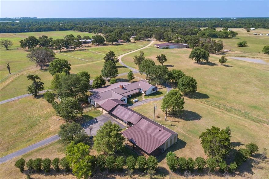 Exceptional 145-Acre Ranch – Just 1 Hour from Dallas! This stunning property features a spacious 3,316 SF, 3-bed, 3-bath home designed for comfort and entertaining. The open-concept layout boasts a large kitchen with custom countertops, stainless appliances, double ovens, an island cooktop, and seamless flow into the oversized living area with a WBFP as the focal point. The expansive primary suite includes a luxurious bath and a massive walk-in closet. Two large guest rooms, a generous utility room, a spacious office, and a 4-car carport provide ample space. Designed as a premier horse ranch, it also supports cattle operations with multiple barns, including a 4,800 SF barn for dry storage, hay storage, equipment, stables, and an outdoor arena. Manicured Bermuda pastures with mature oaks, pipe fencing throughout, and a picturesque setting make this a true Texas gem.