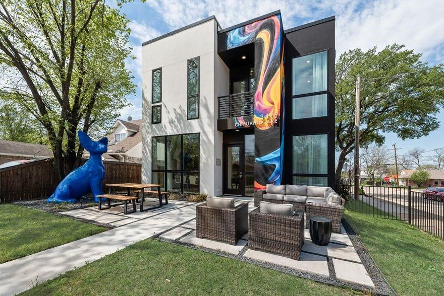 Welcome to the Chihuahua House, a stunning architectural masterpiece that perfectly balances luxury, art, and modern innovation in the heart of the booming Trinity Groves neighborhood. Situated on the prominent corner of Kraft St and Chihuahua Ave, this fresh and iconic property is more than a residence—it is a functional landmark and an Instagram-ready sanctuary. Designed in a cutting-edge Art Minimalist style, the home engages the neighborhood with bold, creative flair, anchored by The Guardian—a monumental, giant blue Chihuahua lawn statue commissioned by local artists. The exterior experience is further enhanced by a white picket-fenced, xeriscaped front lawn and patio for a low-maintenance, high-impact aesthetic, along with an expansive 24-foot artist-designed Groves graffiti mural that celebrates the local culture. A rear driveway ensures seamless access while maintaining the home’s clean, architecturally focused facade. Inside, the home transitions into a bright, modern haven defined by clean lines and premium materials. Massive 10-foot floor-to-ceiling aluminum windows flood the open-concept living spaces with natural light, while the bathrooms are transformed into glowing art pieces as light filters through translucent dichroic film to create a shifting color palette. Artistic details abound, from original Chihuahua-themed accent tiles in the kitchen and baths to a hidden surprise gift sculpture waiting to be discovered. This gem is engineered for performance with continuous insulation for superior thermal efficiency through every Texas season. Located in one of Dallas’s most sought-after districts, you are just steps away from world-class dining, retail, and the Margaret Hunt Hill Bridge. The Chihuahua House offers a rare opportunity to own a piece of functional art in the center of the Trinity Groves action, delivering an unparalleled living experience that is truly one-of-a-kind. All furniture can convey with the sale of the property.