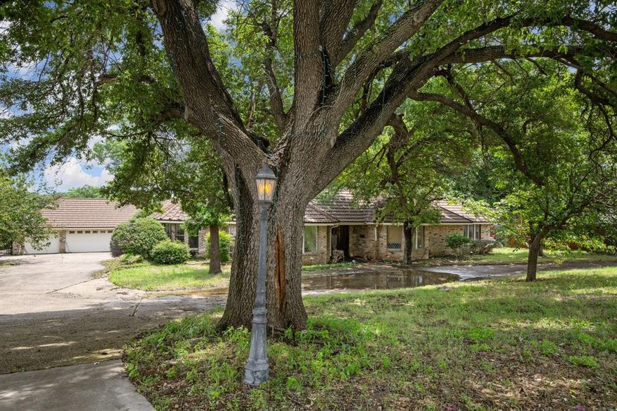 Calling all investors or DIYer's! This one-story custom gem sits on over a half acre lot with a 3 car garage, plus a gate to pull your RV or trailers through into the backyard as well as RV hookups and a circular drive! No HOA and located in a pretty established neighborhood.  New flooring and paint would do wonders for this home and similar sized, nearby, updated homes are selling for $599,000. Other features include a metal shake roof, soaring ceilings with custom built-ins, 2 large living areas, a huge primary suite and bathroom, plus a sunroom and exercise room. Easy access to 2 major highways with 15 minutes to downtown Dallas.