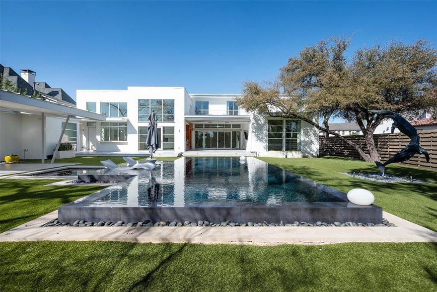In the heart of the Fairway of Preston Hollow, this striking modernist home blends architectural drama with everyday comfort. Designed for both lively entertaining and relaxed family living, its open, light-filled spaces flow effortlessly to the outdoors. Retractable screens create a seamless extension of the main level, opening to 800+ square feet of covered living space. A second outdoor lounge channels mid-century charm with a fire pit beside a striking $400K negative edge pool, hot tub, and tanning ledge—set against a lush, turfed play yard. Inside, soaring ceilings with exposed steel beams and custom finishes define the expansive main level, where a serene primary suite and media room offer retreat. Upstairs, four bedrooms surround a central living area with balcony and bar, while two flex spaces—including a gym with laundry—adapt to any lifestyle. Three-car garage and standing seam metal roof. 2026 updates include: all wood floors professionally refinished, interior walls freshly repainted, stucco refinished, new air conditioning unit installed, pool pump replaced, exterior wood paneling re-stained. With a Control4 system, elevator and climate-controlled wine room, this home is turnkey luxury ready for immediate occupancy.