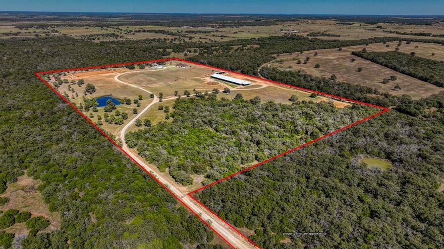 This property carries undeniable value with its easily accessible location just off US Hwy 281. Set on 48.5 acres, as you make your way through the property, you’ll pass the fully stocked pond and peaceful hunting space, often home to grazing deer, on your way back to the beautiful Austin Stone home and the professionally designed training complex. The facility features 85 total stalls, six covered turnout runs, four fully fenced pastures, a brand-new custom Priefert walker, covered round pen, 150’x250’ roping arena, 5 pipe cattle pens, three 50 amp RV plugs, dedicated shavings storage barn, gated entrance, and more. In 2024, the main barn was fully constructed, including 75 (12x12) stalls that easily convert to 38 generous (12x24) stalls, a 3-horse wash bay, and a first-class covered 50’ round pen with 8’ walls, premium footing and a comfortable viewing area overlooking the 370’x80’ horseman's sanctuary. Additional amenities include LED lighting throughout the entire barn, a beautiful custom wood-finished programmable 6-horse Priefert panel walker, and a dedicated 30’x80’ equipment storage barn for all operational needs. The second barn includes 10 stalls with concrete alley, wash bay, six covered runs – perfect for show horses, mares, or yearlings and a walkway to the fully equipped roping arena ready for all of your cow horse needs featuring 5 pipe cattle pens, 2 with automatic waterers. Follow the long, beautiful drive through the property to the secluded 2,700+ sq ft residence, providing a comfortable retreat after long days around the facilities. With an oversized 2 car garage, 4 bedrooms, 3.5 baths, granite countertops, a spacious kitchen island, versatile office or dining space, gas stove, and a cozy rock fireplace. Step out onto the covered back patio, wired for an outdoor TV, and enjoy overlooking treelined pastures and a rock fire pit, creating the perfect spot to unwind or entertain.