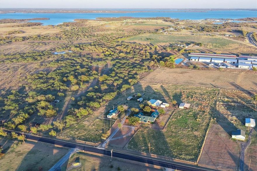 Discover this breathtaking 7 acre estate just minutes from Lake Ray Roberts! A true North Texas treasure built with love, craftsmanship, and vision. Custom built by the original owners as their dream home, this ranch style retreat offers stunning sunsets, wide open pastures, and every amenity needed for comfortable country living. A picturesque 7 acres fully fenced with popping cable fencing, cross-fenced pastures, coastal and native grasses ideal for baling, and thoughtfully designed livestock areas. The property includes a hay barn, cattle chutes, and beautiful barn with multiple bays that make it turnkey for horses, cattle, or your perfect hobby ranch. Workshop with office space. Step inside the meticulously maintained, thoughtfully upgraded home featuring: A gourmet family kitchen with upgraded granite countertops, a large island, double ovens, and rich pecan wood cabinetry, Three stunning fireplaces throughout the home, All-new windows and all-new flooring, Oversized living areas perfect for gathering and entertaining, Huge bedrooms, each designed with comfort and space in mind. The master suite is truly exceptional featuring two walk in closets, a spa-inspired shower, a sunken soaking tub, and private doors leading directly to the expansive patio overlooking your ranch and those phenomenal sunsets. The game room feels like its own private hideaway with its own fireplace, bar, refrigerator, ice machine, and private entrance which is ideal for a teen retreat, guest hangout, or entertaining space. A separate 2 bedroom, 1 bath accessory dwelling (formerly home to the owner’s mother) provides endless possibilities. Use it as a guest house, a mother-in-law home, staff quarters, or an income producing rental which is perfect for extended families or someone to help care for the land, horses, or cattle. Located in highly sought-after Sanger, Texas, and just moments from Lake Ray Roberts, this estate blends peaceful country living with incredible convenience.