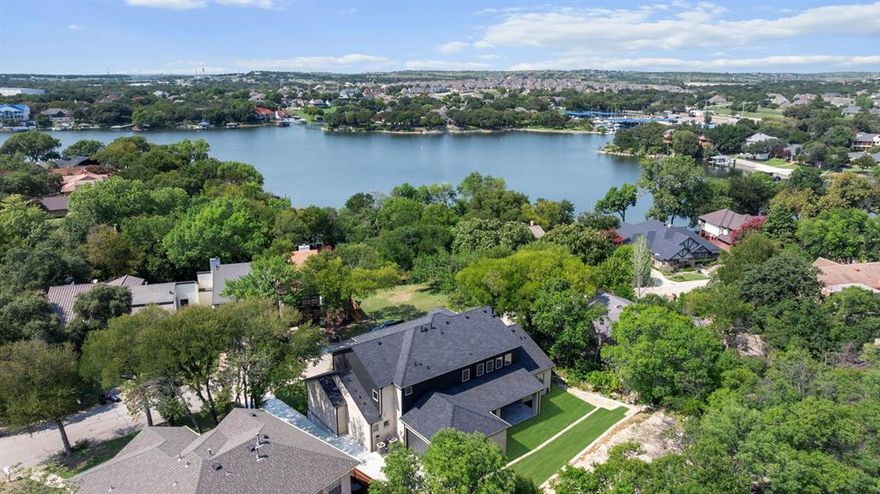 Lake living at its finest! Nestled across the street from the tranquil waters of Eagle Mountain Lake, this beautiful new construction home is move-in ready with exquisite finishes throughout. Step inside to be greeted by vaulted ceilings, creating a grand entrance with eye-catching cascading chandeliers.  The desirable open floorplan allows for seamless living from kitchen to dining to living.  The heart of the home is the gourmet kitchen, featuring luxurious waterfall quartz countertops, large kitchen island with a high end sink workstation, double ovens, and a 5-burner gas cooktop.  Huge pantry room is located next to the separate laundry room, both offering multiple shelves for storage and organizing.  Downstairs not only features a luxurious primary suite with a jaw dropping bathroom and huge closet, but also a guest suite - the most desirable floorplan.  While upstairs features a large open gameroom with a long balcony for doing sunset, and 3 bedrooms, plus a large guest bathroom with gorgeous tile work.  From the downstairs slider doors, enjoy a large covered patio facing East, creating additional shade for those backyard BBQs.  Enjoy the community's rich amenities, including access to the gated private boat ramp - boat launch located just a few steps at the end of the street, fishing docks, parks, and green belts, all part of a voluntary HOA. Embrace the serene lifestyle with easy lake access (just down the road) and the comfort and efficiency of a brand-new home.  Don’t miss this opportunity to own a piece of paradise at Eagle Mountain Lake!