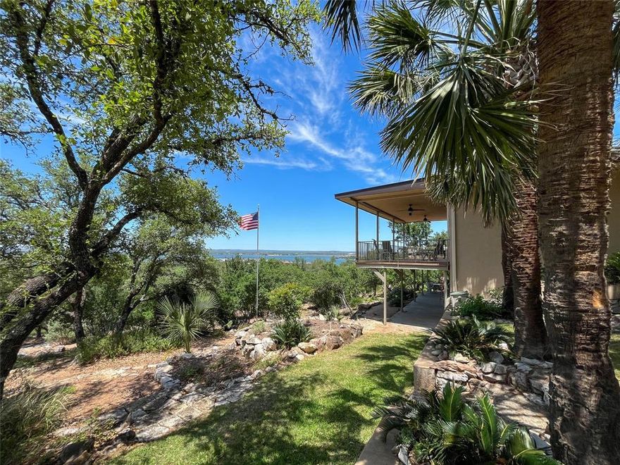 Sprawling 3998 sq ft hilltop home offers panoramic views of Lake LBJ and Texas Hill Country with a secluded feel and spectacular
sunsets from the spacious covered deck. Enjoy the expansive lake views from the open living and dining rooms. While preparing
and eating meals in the kitchen you can watch the boaters on the lake below. Wake to beautiful lake views in the primary
bedroom. The primary bath offers an updated barrier free shower and the home has all primary needs on one level. You will
appreciate the relaxing views of nature from the lower-level office as you work from home. From there step into the family room or
stroll out the French doors to stretch your legs on the inviting paths landscaped into your downhill lot. The two lots, platted together
, offer mature palms and abundant flowers. The main floor offers an additional two bedrooms, full bath and access to a lower-level
studio apartment with a den, small kitchen, bedroom and full bathroom. It has its own private entrance and private deck and could
be turned into a lock off apartment for short term rental, caregiver, or multi-generational living. This property includes a climate
controlled workshop or golf cart garage. Great location in HSB North minutes from the HSB yacht club and marina, pools and spas,
pickleball and tennis courts, and world-class golfing at Robert Trent Jones and Jack Nicklaus golf courses. Enjoy full-time living or
fly in for the weekend to the private HSB jet center.