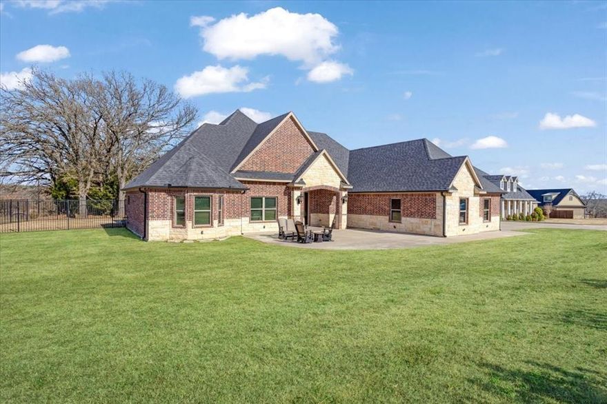 This stunning custom-built one-story home offers luxury, space, and thoughtful design throughout its 4 bedrooms, 2.5 bathrooms, and 3,017 square feet of living space, with an impressive 4,733 square feet under roof. Situated on a large corner lot, the property features a wrought iron fence and privacy trees along the rear, creating a private and inviting setting. Designed for both comfort and entertaining, the home boasts a massive covered back porch and an oversized front porch, perfect for gatherings or quiet evenings outdoors. Inside, upscale finishes abound, including solid custom wood cabinetry, quartz countertops, luxury LVP flooring, and top-of-the-line stainless steel appliances. The open-concept living area features a gas fireplace and flows seamlessly into the kitchen and dining area, making it ideal for everyday living and entertaining. All bedrooms are generously sized and include walk-in closets for ample storage. The oversized 1,261-square-foot, 4-car garage offers exceptional functionality and includes a walk-in cedar closet. The primary suite is a true retreat, featuring room for a sitting area, a spa-like bathroom, and a walk-through closet that connects directly to an over-the-top utility room. With too many custom upgrades to list, this one-of-a-kind home seamlessly blends luxury, functionality, and timeless craftsmanship. Conveniently located near highways, hospitals, shopping, and schools, this property offers refined living in a prime location.